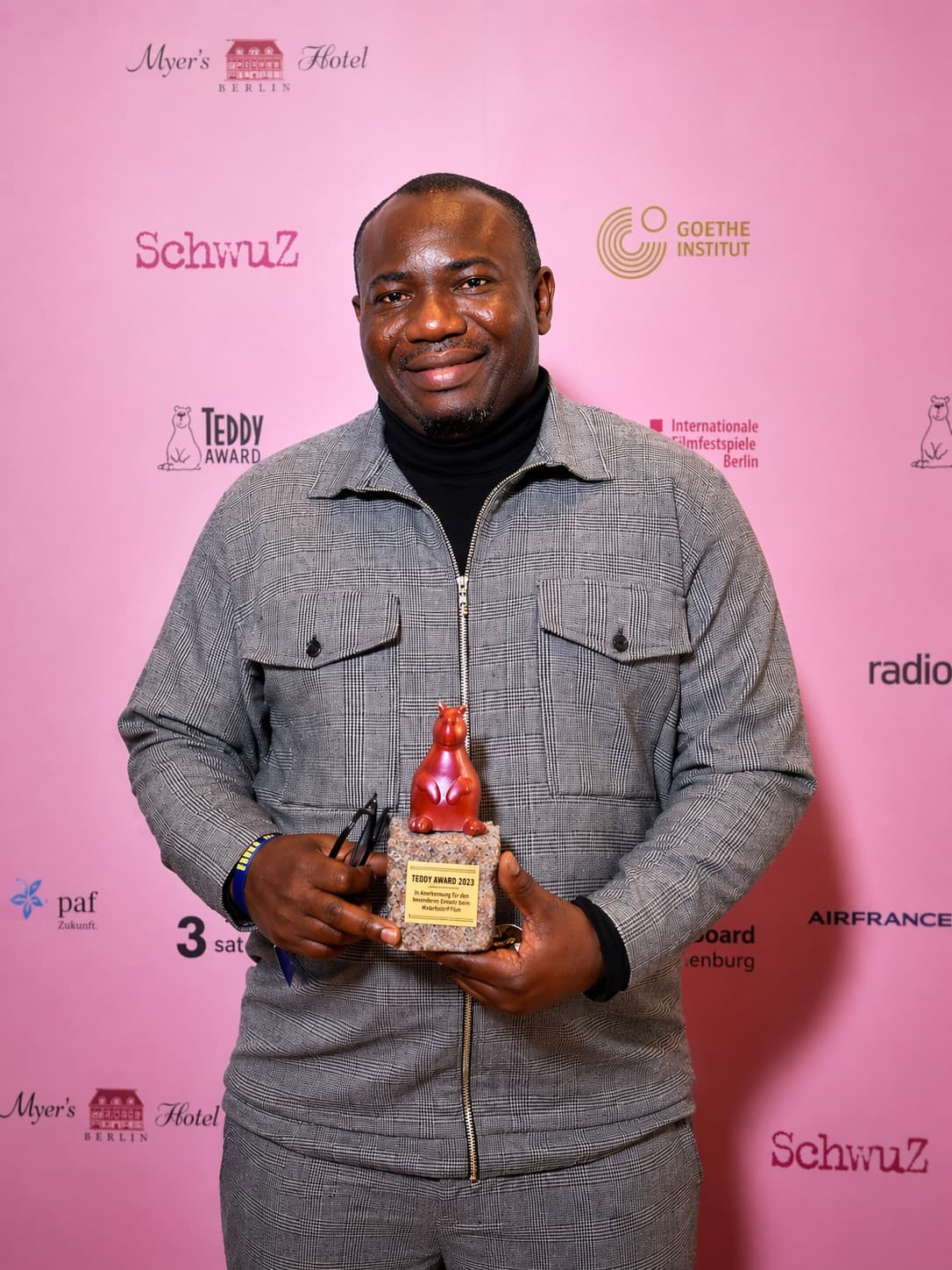 Imafidon Gift Jesurobo-Owie holding the Teddy Award at Berlinale